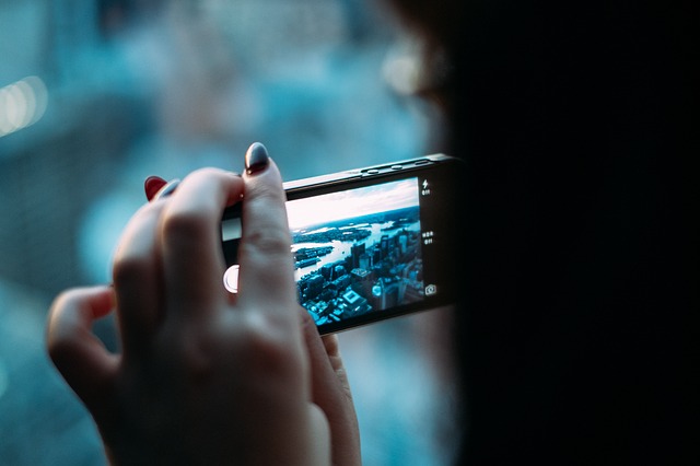 A womans hand holds a smartphone taking a photograph